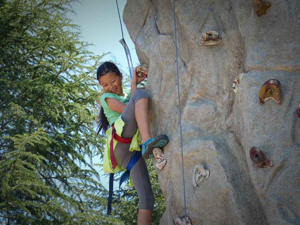 Girl climbing rock wall at Dorris-Eaton summer camp